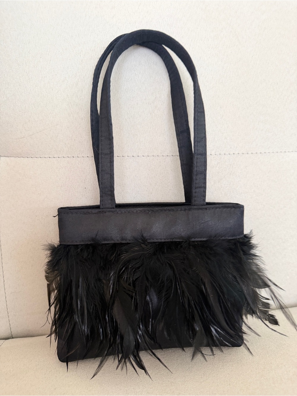 Reaction/Kenneth Cole–type small black evening handbag with feather trim.